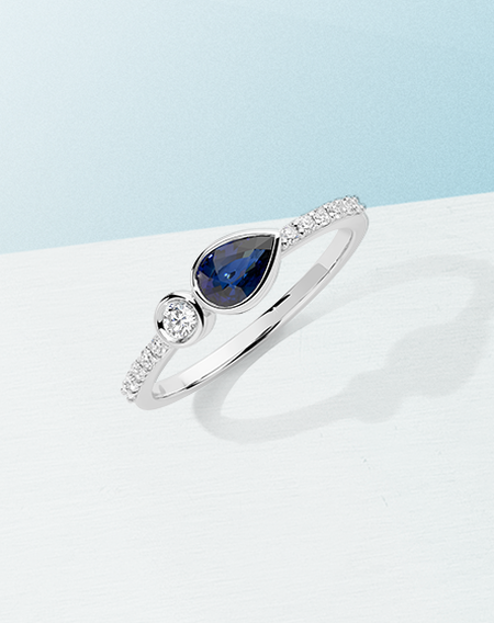 Birks Splash sapphire and diamond ring on a light blue background.